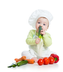 baby boy wearing a chef hat with healthy  food vegetables