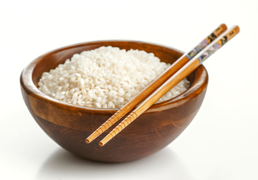 Wooden bowl with rice and Chinese chopsticks
