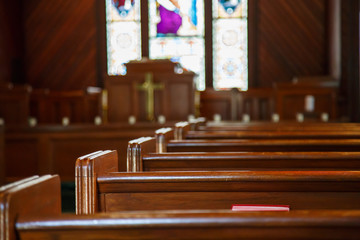 Church Pews with Stained Glass Beyond Pulpit - obrazy, fototapety, plakaty