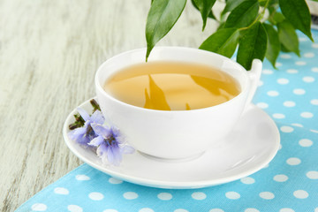 Cup of tea with chicory, on wooden background