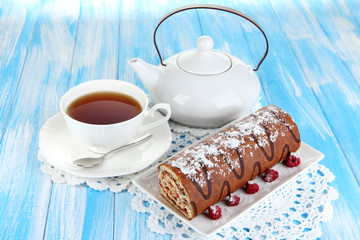Sweet roll with cup of tea on table close-up