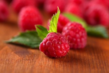 Ripe sweet raspberries on wooden background