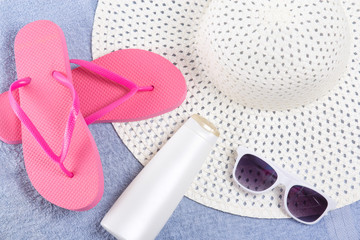 flip flops, hat, sunglasses over blue towel