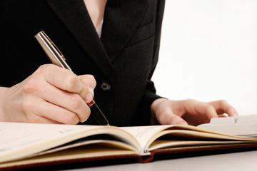 Woman's hand holding a pen writing a text