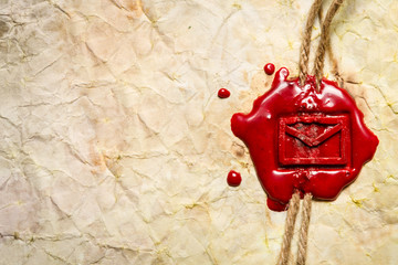 Closeup of envelope symbol imprinted in red sealing wax