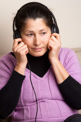 Fototapeta premium Asian woman listening to music on headphones