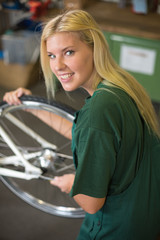 Fahrradmechanikerin repariert Fahrrad in einer Werkstatt