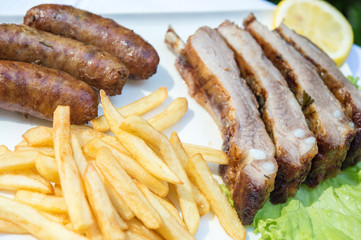 Costine e salsicce alla griglia con patatine fritte