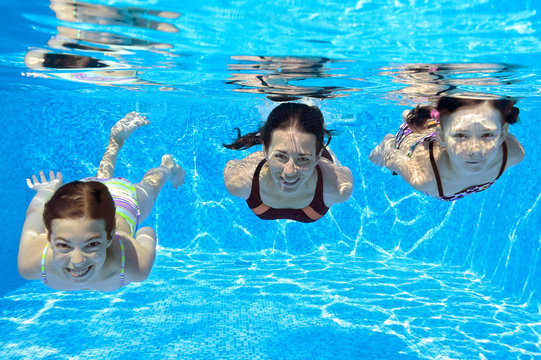 Happy family swim underwater in pool, having fun on vacation