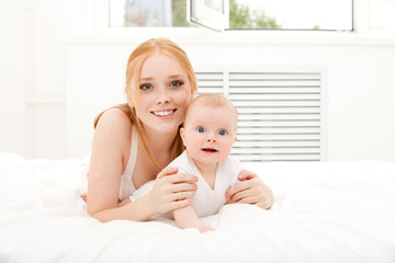 mother lies on carpet with baby