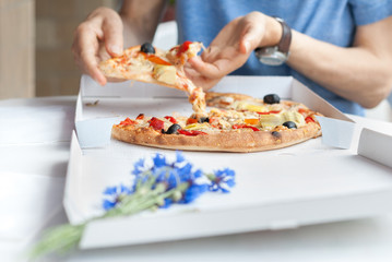 Obraz na płótnie Canvas Eating pizza - Grabbing a slice of pizza from delivery box