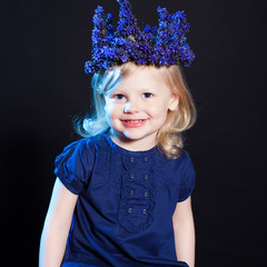 Little cute girl posing in crown of blue flowers