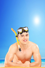 Young man wearing a snorkeling mask on a beach