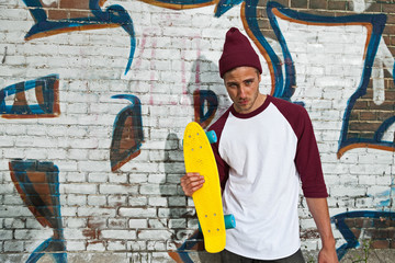 Hip cool urban fashion skateboarder with woolen hat posing in fr © ysbrandcosijn