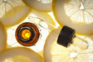 Essential oil amber glass bottle with slices of lemon - 53860523