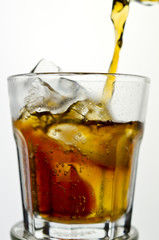 cola being poured in to a glass from a height