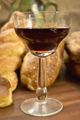 Still life assortment of bread with a glass of red wine.
