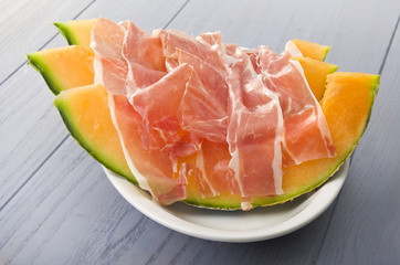 Ham and cantaloupe melon on the gray table
