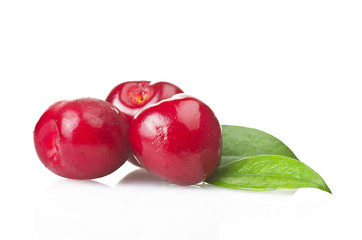 Fresh cherries and leaves close up on white