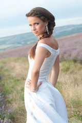 Fototapeta na wymiar Young and beautiful bride in lavender field