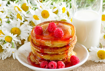 Homemade pancakes with raspberry jam and milk