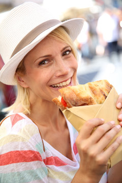 Cheerful Blond Girl In Rome Eating Focaccia Sandwich