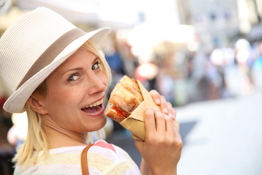 Cheerful Blond Girl In Rome Eating Focaccia Sandwich