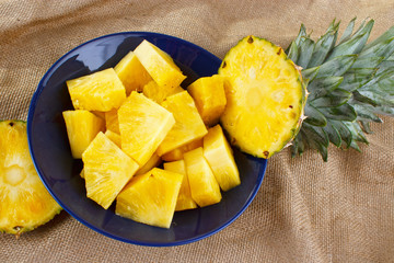 Cut fresh pineapple on dish with green leaves