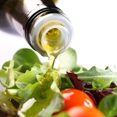 Close-up of olive oil pouring on salad.