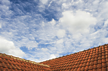 Tiled Roof with Fluffy Cloud Blue Sky
