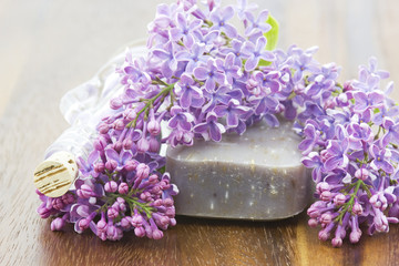 bar of natural soap, bath salt and lilac flowers