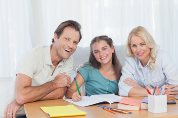 Parents helping her daughter to do her homework