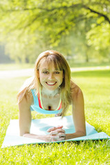Woman holding plank pose outside