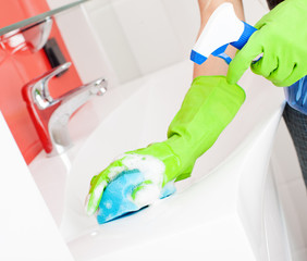 Woman cleaning sink and faucet