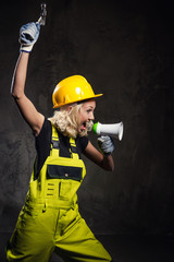 Attractive builder woman shouting through megaphone