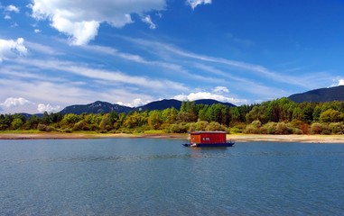 Fototapeta na wymiar Houseboat and mountains in summer