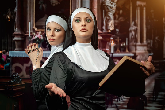 Nuns With Rosary And Bible Praying In The Church