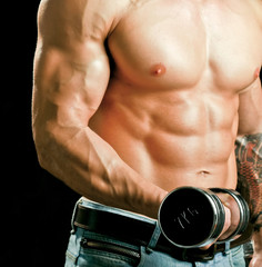 Naklejka premium Handsome muscular man working out with dumbbells