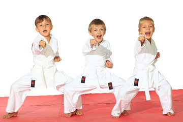 Fototapety  Troje dzieci w kimonie uderzyło pięścią na białym tle