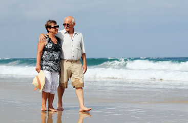 Happy senior couple walking together on a beach