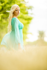 Fototapeta na wymiar Young blond woman in the field