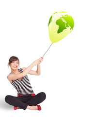 Happy lady holding a green globe balloon