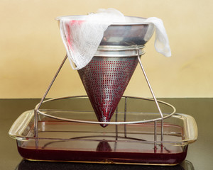 Filtering fresh strawberries to make jelly