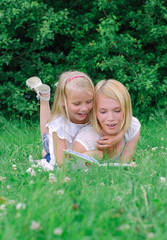 Mother and daughter reading book in the park