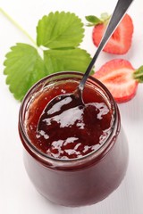 Glass with strawberry jam and fresh strawberries
