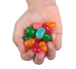 Child's hand full of jelly bean candy isolated on white