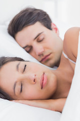 Fototapeta na wymiar Portrait of a pretty woman sleeping next to her partner