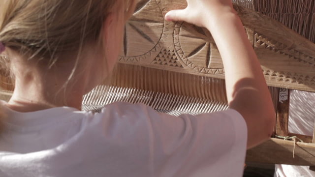 Girl working with traditional loom