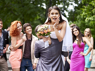 Groom carries his bride over shoulder.
