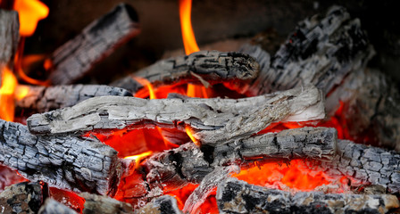 Wooden embers close-up on a whole background